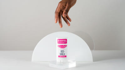 woman hand reaching for schmidt's rose + vanilla signature deodorant stick with magnesium
